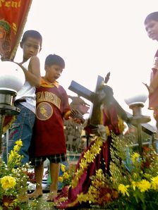 Children waiting for the image of the Black Nazarene to pass by P. Burgos Avenue in Manila